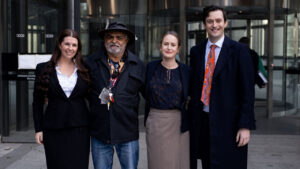 Uncle Dennis who filed legal challenge to access age pension earlier, standing with legal team.
